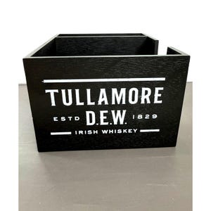 Può includere: Scatola di legno nera con la scritta bianca "Tullamore D.E.W. Irish Whiskey". La scatola ha due scomparti ed è in legno. Il testo include "ESTD 1829".