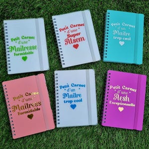 Peut inclure: Six carnets à spirales de différentes couleurs, dont blanc, turquoise, rose et corail. Chaque carnet possède une fermeture élastique verticale et un texte en français imprimé sur la couverture, comme Petit Carnet d'une Maîtresse Formidable ou Petit Carnet d'un Maître trop cool, accompagné d'une petite icône en forme de cœur.