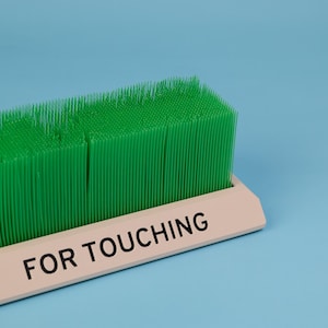 Touch Grass desk toy close up green grass bristles for touching label detail