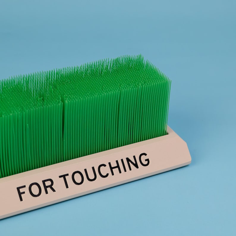 Touch Grass desk toy close up green grass bristles for touching label detail