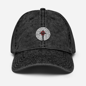 Puede incluir: Una gorra de béisbol de denim negro desgastado con un diseño bordado en blanco y rojo. El diseño presenta una estrella con una cruz en su interior y las palabras "MIDNIGHT" y "MASS" alrededor de la estrella.