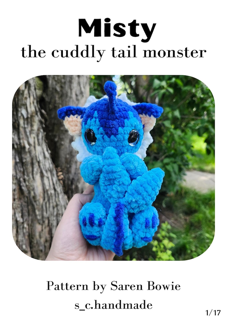 May include: A handmade blue crochet monster toy with the text "Misty the cuddly tail monster." The toy has large black eyes, blue and white accents, and a long tail. The pattern is by Saren Bowie.