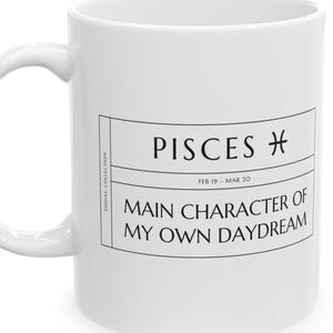 Può includere: Una tazza in ceramica bianca con un design rettangolare stampato in nero. Il testo recita PISCES con il simbolo zodiacale, FEB 19 - MAR 20, e MAIN CHARACTER OF MY OWN DAYDREAM. Il lato include il testo verticale ZODIAC COLLECTION.