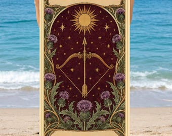 May include: A rectangular beach towel featuring a dark red background with a gold sun, bow, and arrow illustration. The text SAGITTARIUS appears at the top and ZARA at the bottom, framed by green thistle plants and gold decorative borders.