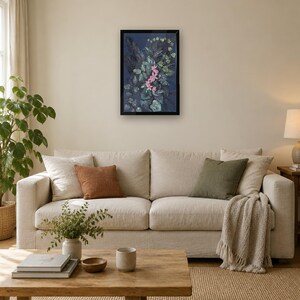 May include: A framed rectangular wall art piece featuring a dark blue background with a central cluster of pink flowers surrounded by textured green and dark foliage, encased in a simple black frame hanging on a neutral wall.