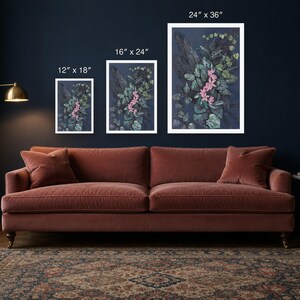 May include: Three rectangular wall art prints featuring a dark blue background with green foliage and pink flowers. The prints are labeled with dimensions of 12" x 18", 16" x 24", and 24" x 36" respectively, displayed in white frames.