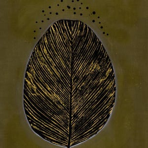 May include: A vertical oval artwork featuring a central black leaf shape with prominent gold veins. The leaf is set against a solid olive green background, with a series of small black dots arranged in an arc above the top of the leaf.