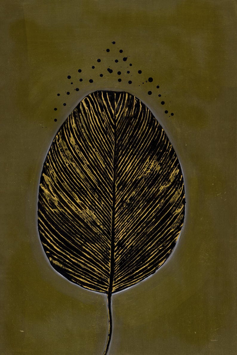 May include: A vertical oval artwork featuring a central black leaf shape with prominent gold veins. The leaf is set against a solid olive green background, with a series of small black dots arranged in an arc above the top of the leaf.