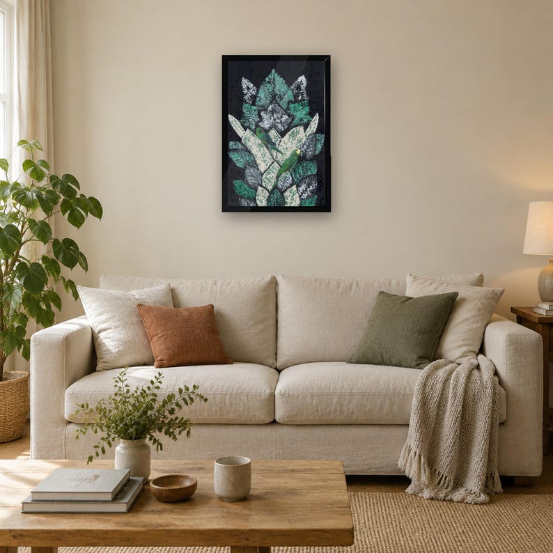 May include: A rectangular framed wall art piece featuring a symmetrical, layered leaf pattern in shades of dark green, light green, and white against a black background, displayed in a thin black frame on a plain wall.