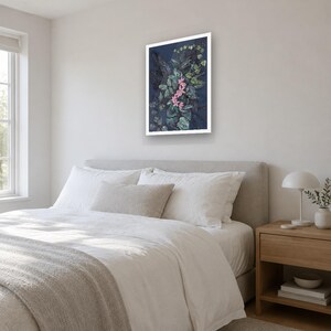 May include: A rectangular wall art print featuring a dark navy blue background with a dense arrangement of green foliage and a central cluster of small, vibrant pink flowers, all enclosed within a clean, white frame.