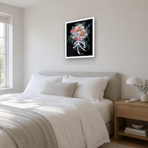 May include: A framed wall art print featuring a vibrant bouquet of multi-colored flowers including pink, orange, and blue blossoms with green foliage, tied together with a white ribbon against a solid black background.