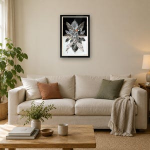 May include: A framed vertical wall art print featuring a stylized black and white botanical arrangement of layered leaves. A small toucan with a bright orange beak is perched among the foliage. The artwork is set against a dark background.