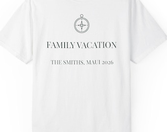 May include: A white short-sleeved t-shirt featuring a black graphic of a compass icon centred above the text FAMILY VACATION and the text THE SMITHS, MAUI 2026. The shirt has a crew neckline and a standard fit, with a small brand label at the neck.