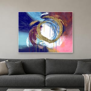Puede incluir: Una pieza de arte mural rectangular que presenta una composici&oacute;n abstracta con una pincelada circular dorada central. El fondo muestra capas mezcladas de azul profundo, rosa brillante y blanco con goteos verticales en oro, azul y rojo.