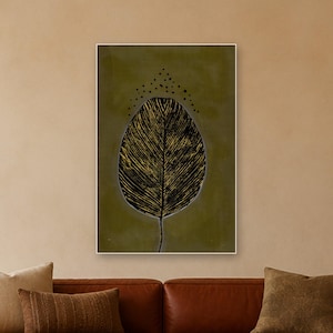 May include: A rectangular wall art print featuring a large, central leaf illustration with black and gold textured veins against a solid olive green background. Above the leaf, a series of small black dots form an arching pattern.