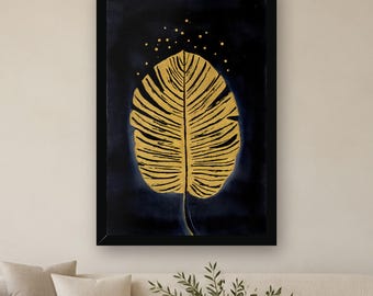 May include: A framed wall art print featuring a large, detailed golden leaf centered against a deep navy blue background. Above the leaf, small golden dots are scattered, creating a subtle speckled effect within the black frame.