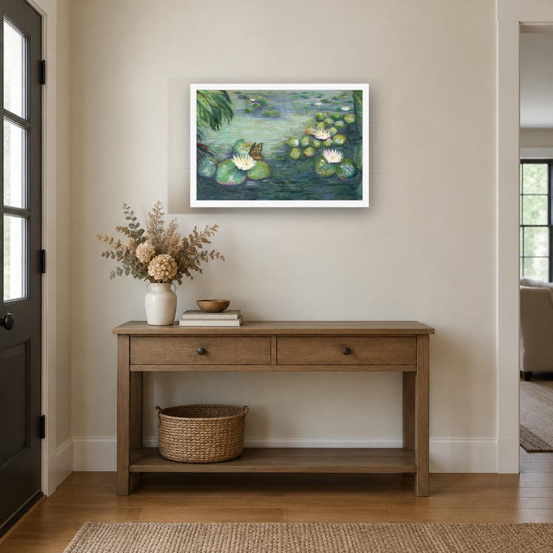 K&ouml;nnte beinhalten: Ein gerahmter Wandkunstdruck, der eine Teichszene mit wei&szlig;en Seerosen, gr&uuml;nen Seerosenbl&auml;ttern und einem Schmetterling zeigt. Das Kunstwerk h&auml;ngt &uuml;ber einem h&ouml;lzernen Konsolentisch mit zwei Schubladen, einer Vase und einem Korb.