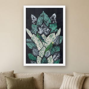 May include: A framed rectangular wall art print featuring a vertical arrangement of layered, textured leaves in shades of dark green, light green, and white against a solid black background, with two small green parrots perched among them.