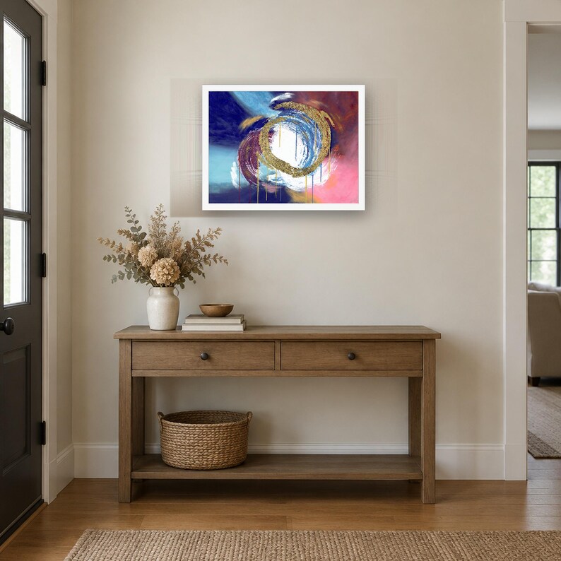 Puede incluir: Una impresi&oacute;n de arte mural rectangular que presenta una composici&oacute;n abstracta con un remolino circular central de textura dorada. El fondo muestra trazos mezclados de azul profundo, azul claro, magenta y blanco con gotas de pintura dorada vertical.