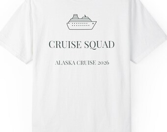 May include: A white short-sleeve t-shirt featuring a black line drawing of a cruise ship centered at the top. Below the ship, the text reads CRUISE SQUAD in a bold font, followed by the text ALASKA CRUISE 2026 in a smaller, thinner font.