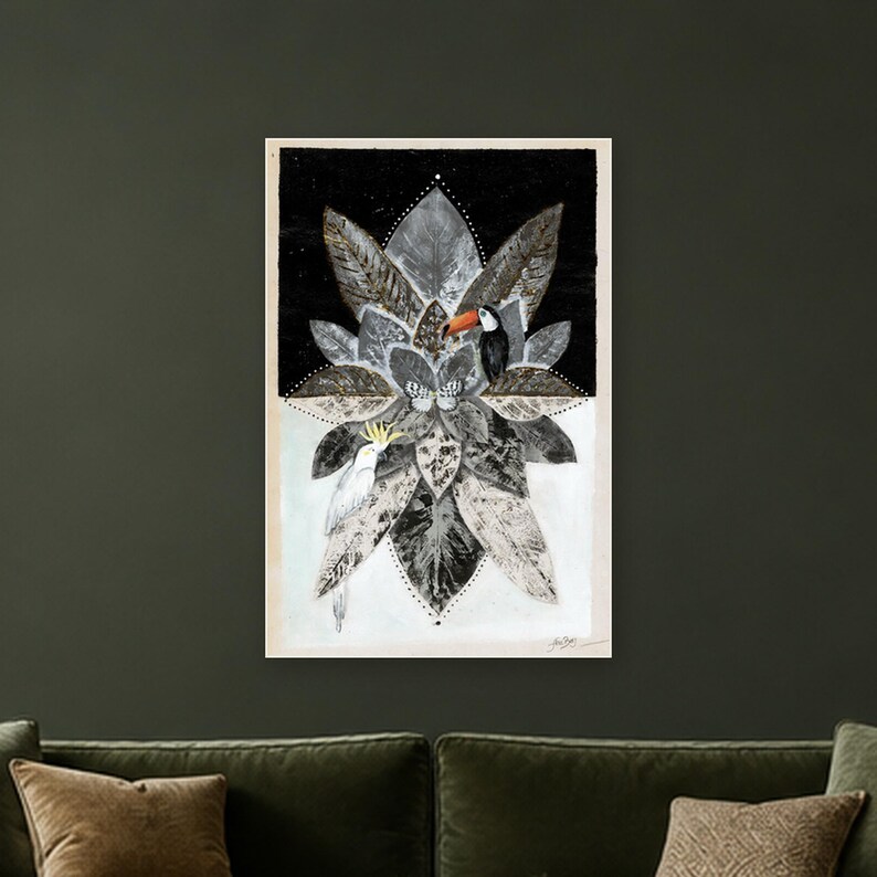 May include: A rectangular wall art print featuring a central mandala-like arrangement of grey and black leaves. A toucan with an orange beak and a white cockatoo with a yellow crest are perched among the foliage. A small butterfly is centered.