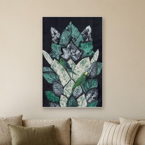 May include: A rectangular wall art piece featuring a dark black background with a central vertical arrangement of overlapping leaves in shades of teal, sage green, and white. Two small green parrots are perched among the foliage.