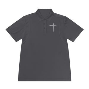 May include: Dark gray polo shirt with a white cross and nail design on the left chest. The shirt has a collared neckline and short sleeves. The fabric appears to be a lightweight, breathable material.