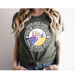 May include: A green t-shirt with a white circle graphic that says "Your Grup Name Your Location Vacation 2023 Sea | Sand | Sun". The graphic features a colorful illustration of various landmarks and a cruise ship.