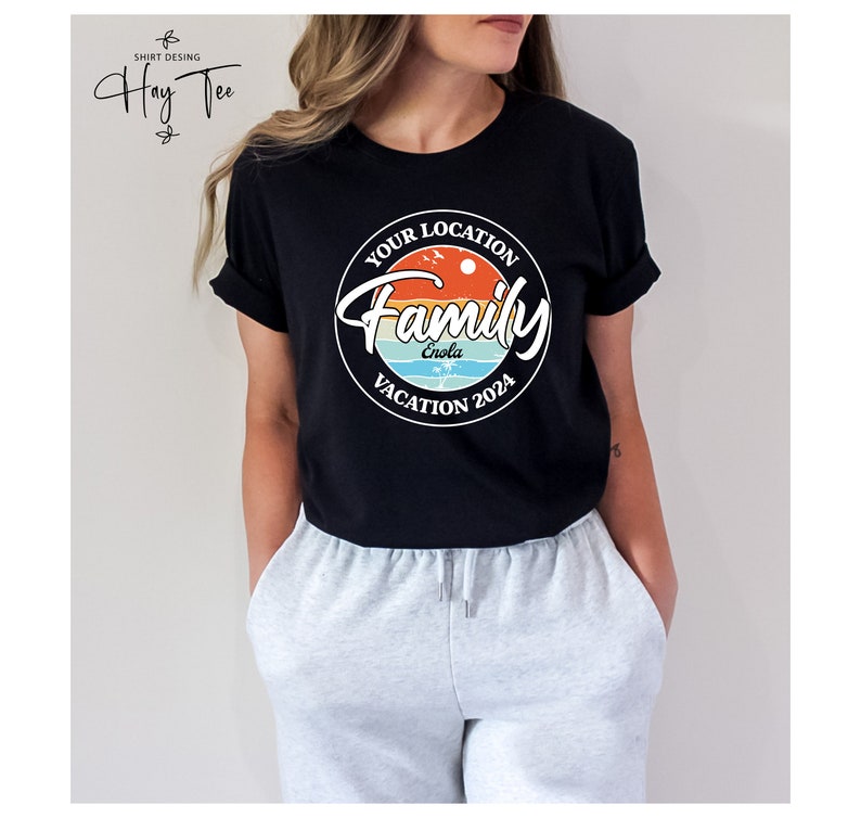 K&ouml;nnte beinhalten: Schwarzes T-Shirt mit einem wei&szlig;en Kreis-Motiv, auf dem "Your Location Family Vacation 2024" steht, wobei das Wort "Enola" im Kreis steht. Das Motiv hat ein Sonnenuntergangsdesign mit Palmen und V&ouml;geln.