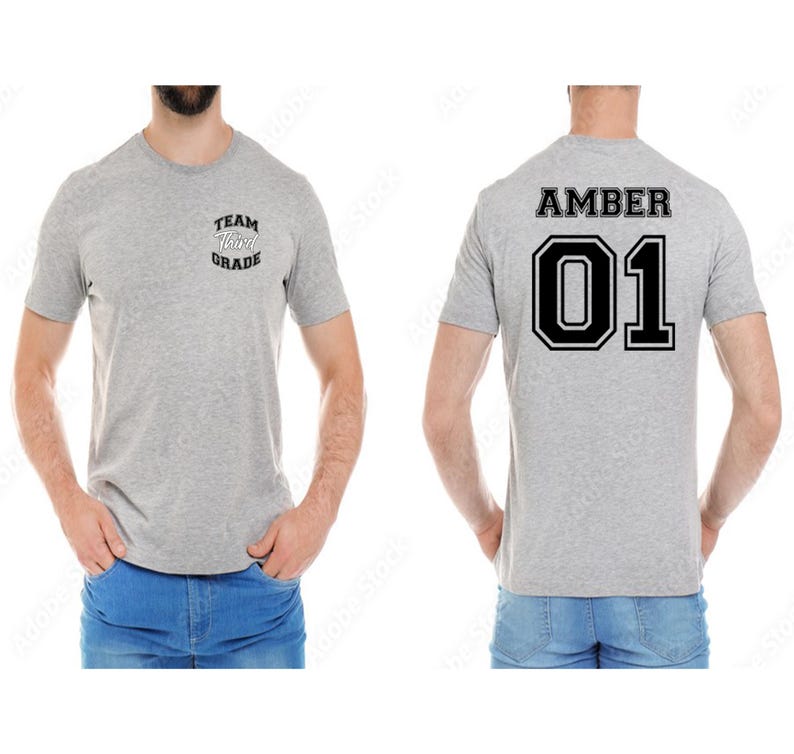 May include: A light gray t-shirt with the text "TEAM Third GRADE" on the front and "AMBER 01" on the back. The shirt is short-sleeved and made of a soft material.