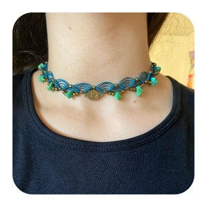 May include: A turquoise and gold choker necklace with a decorative pendant and turquoise beads.