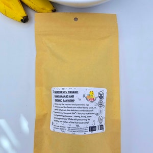 May include: A brown paper bag with a label that reads "INGREDIENTS: ORGANIC RAH BANANAS AND ORGANIC RAW HEMP". The label also includes a logo with the text "Chewy Fruitritious" and a list of ingredients.