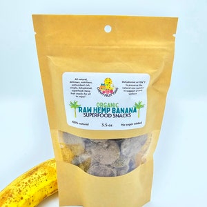 May include: A brown paper bag with a clear window showing organic raw hemp banana superfood snacks. The bag has a green logo with the text "Chewy Fruit Yums" and the text "Organic Raw Hemp Banana Superfood Snacks". The bag also has the text "100% natural", "3.5 oz", and "No sugar added".