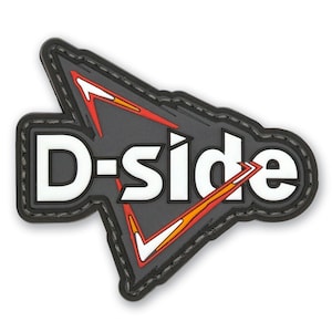 May include: A triangular-shaped patch with a dark gray background and a black border. The text D-SIDE is printed in bold white letters across the center. The design features stylized red and orange arrow accents pointing upward and downward.