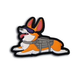 May include: A colorful, cartoon-style patch featuring a corgi dog wearing sunglasses and a tactical vest. The dog is orange, white, and black, with its tongue sticking out. The patch has a black border and is designed to be attached to clothing or gear.