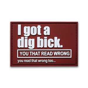 May include: A rectangular patch with the text "I got a dig bick. YOU THAT READ WRONG you read that wrong too..." in white, bold letters. The patch has a dark red background and a white border around the text.