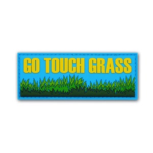 May include: A rectangular patch with a bright blue background featuring the yellow text GO TOUCH GRASS in a bold sans-serif font. Below the text is a graphic illustration of green grass blades with dark green outlines and shadows.