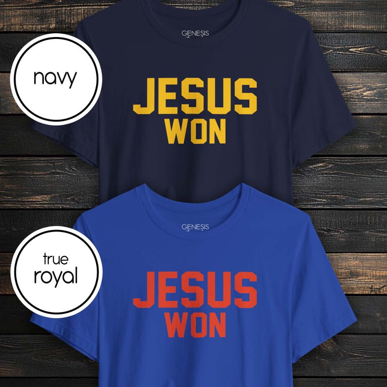 May include: Two short-sleeve crew neck t-shirts. The top shirt is navy blue with yellow text that reads JESUS WON. The bottom shirt is true royal blue with orange text that reads JESUS WON. Both shirts feature the brand name GENESIS at the neckline.