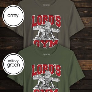 Puede incluir: Dos camisetas de manga corta y cuello redondo en colores verde ej&eacute;rcito y verde militar. El gr&aacute;fico muestra una figura haciendo flexiones con una cruz de madera en la espalda, con el texto "LORD'S GYM" y "THE SIN OF THE WORLD" en rojo y blanco.