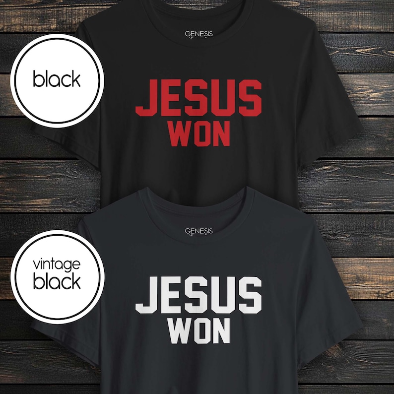 May include: Two short-sleeve crew neck t-shirts with the text "JESUS WON" printed on the chest. The top shirt is black with red lettering, and the bottom shirt is vintage black with white lettering. Both shirts feature the brand name "GENESIS" printed.