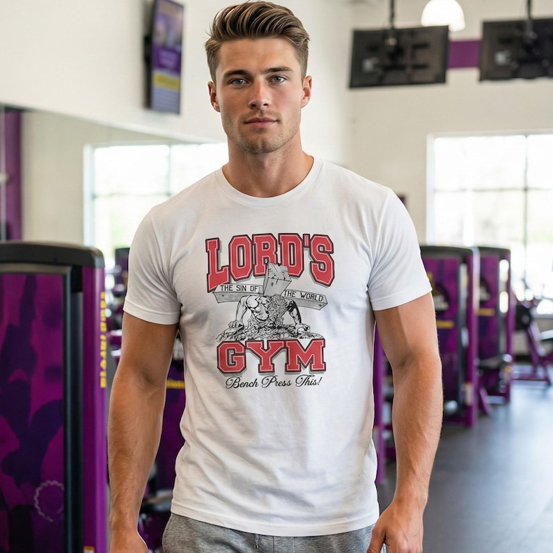 May include: White t-shirt with the text "LORD'S GYM" in red, featuring a graphic of a weightlifter and the words "The Sin of the World". The shirt also says "Bench Press This!"