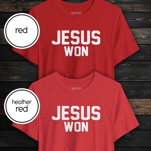 May include: Two short-sleeved crew neck t-shirts, one in solid red and one in heather red. Both shirts feature the text "GENESIS" in small white letters near the neckline and the bold white text "JESUS WON" centered on the chest area.