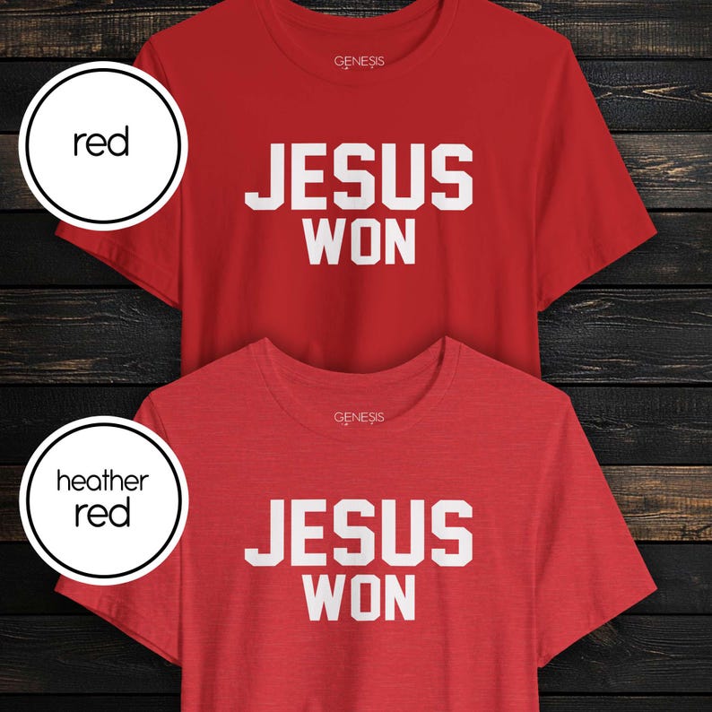 May include: Two short-sleeved crew neck t-shirts, one in solid red and one in heather red. Both shirts feature the text "GENESIS" in small white letters near the neckline and the bold white text "JESUS WON" centered on the chest area.