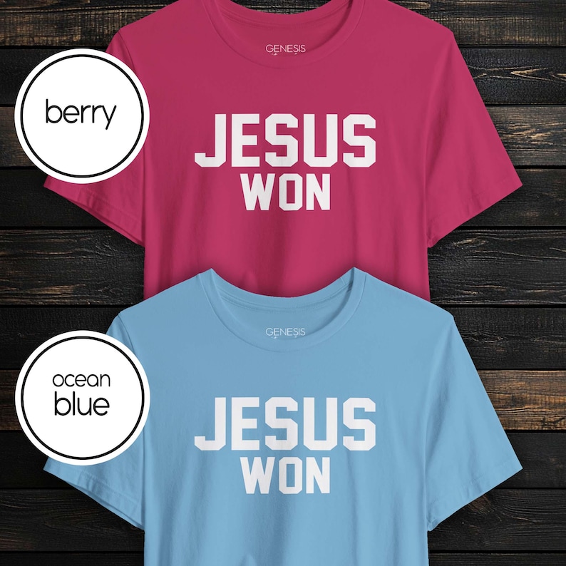 May include: Two short-sleeve crew neck t-shirts, one in berry and one in ocean blue. Both shirts feature the text "JESUS WON" in bold white block lettering on the chest and the brand name "GENESIS" printed in small white letters near the neckline.