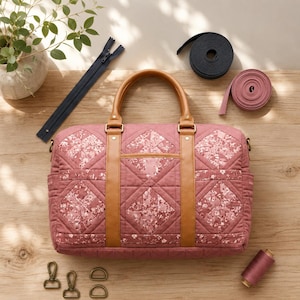 May include: A dusky pink quilted duffel bag with brown leather details and handles. The bag has a floral pattern and is surrounded by sewing supplies, including a zip, ribbon, and thread. Metal hardware and a spool of thread are also visible.