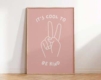 Op de afbeelding: Een roze ingelijste poster met een wit vredesteken en de tekst "It's cool to be kind."