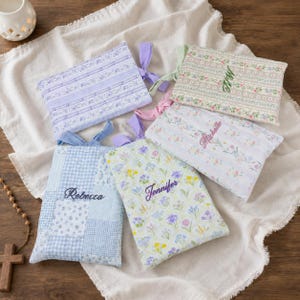 May include: Five rectangular fabric pouches with ribbon ties, featuring various floral and gingham patterns in pastel colors. Three pouches are embroidered with the names Rebecca, Jennifer, and Michelle in cursive script, while one features initials.