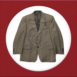 Puede incluir: Una chaqueta de tweed marrón con cierre de dos botones y bolsillos de solapa.