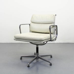 May include: A cream-colored office chair with a five-star base and armrests. The chair features a padded seat and backrest, and a silver-colored metal frame. The chair is designed for comfort and support, suitable for a home or office setting.