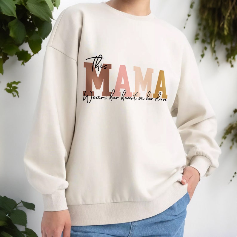 Custom This Mama Wears Her Heart On Her Sleeve Sweatshirt, Personalized Mom Hoodie With Kids Names, Cute Momma Outfit, Mothers Day Gift Idea zdjęcie 1